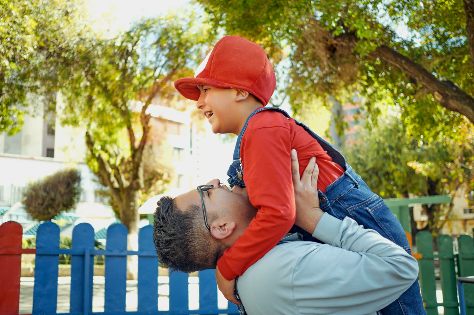 A Latino father and his young son sharing a joyful moment together
